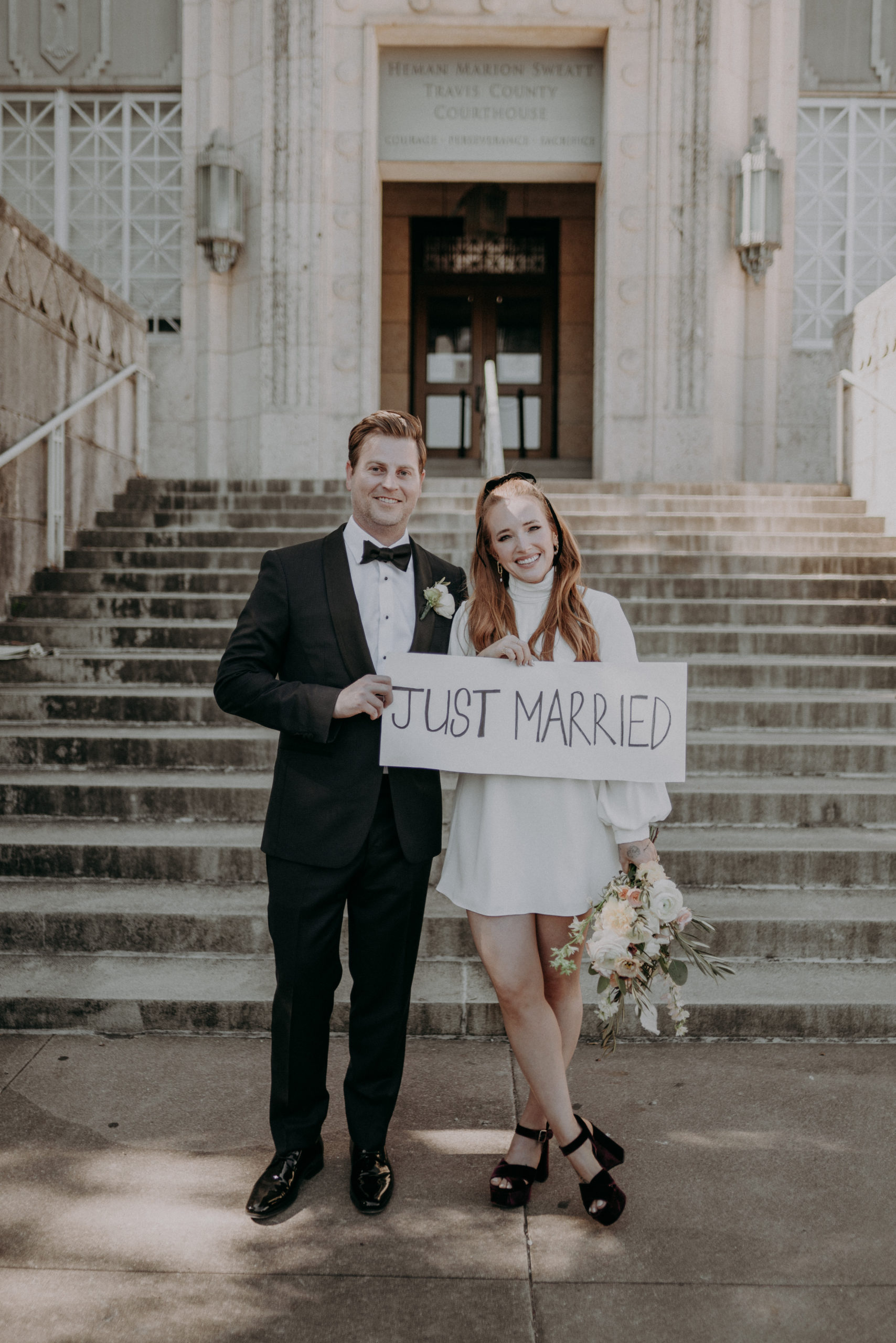 Couple in front of Courthouse holding just married sign