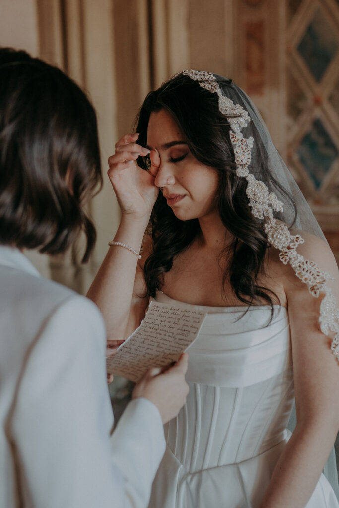 Bride wiping tear during emotional vow exchange at Bethesda Terrace Central Park NYC elopement
