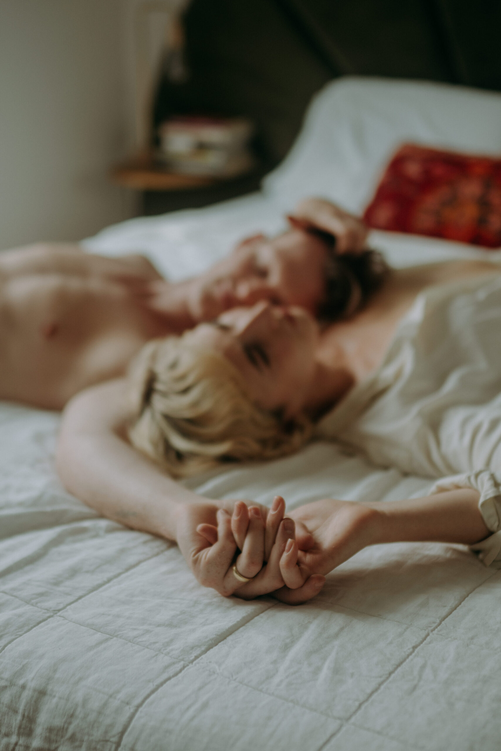 Couple cuddling in bed during intimate couple session NYC morning light natural unposed photography