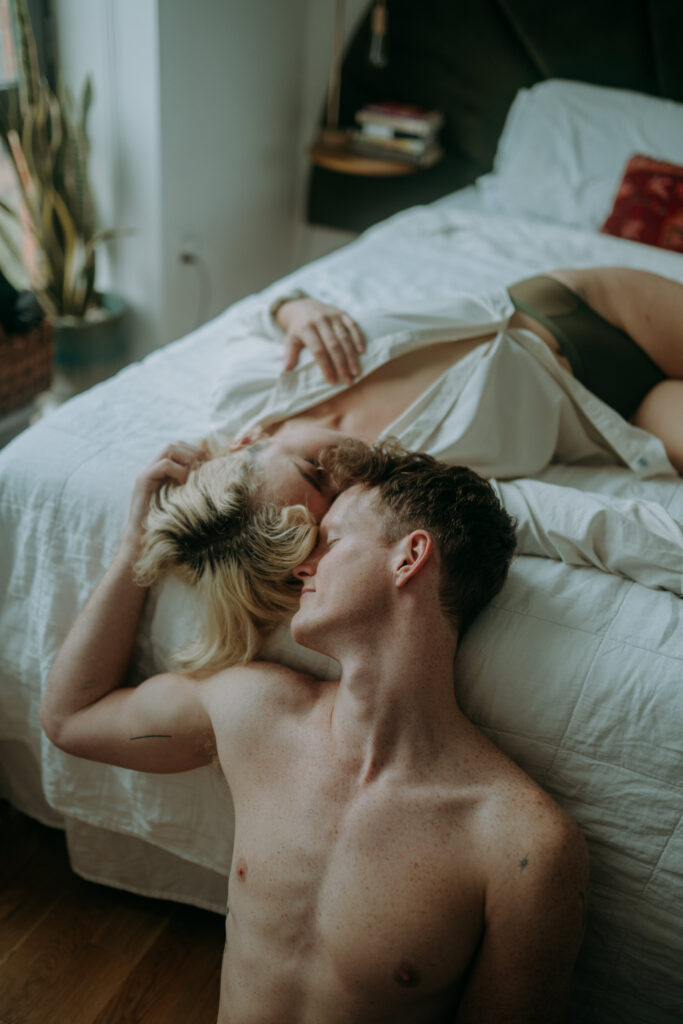 Couple cuddling in bed during intimate couple session NYC morning light natural unposed photography