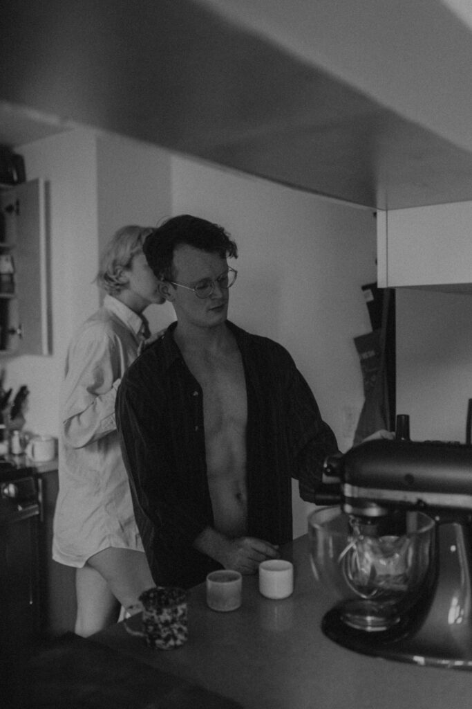 Black and white photo of couple making coffee together in small NYC kitchen during intimate couple session
