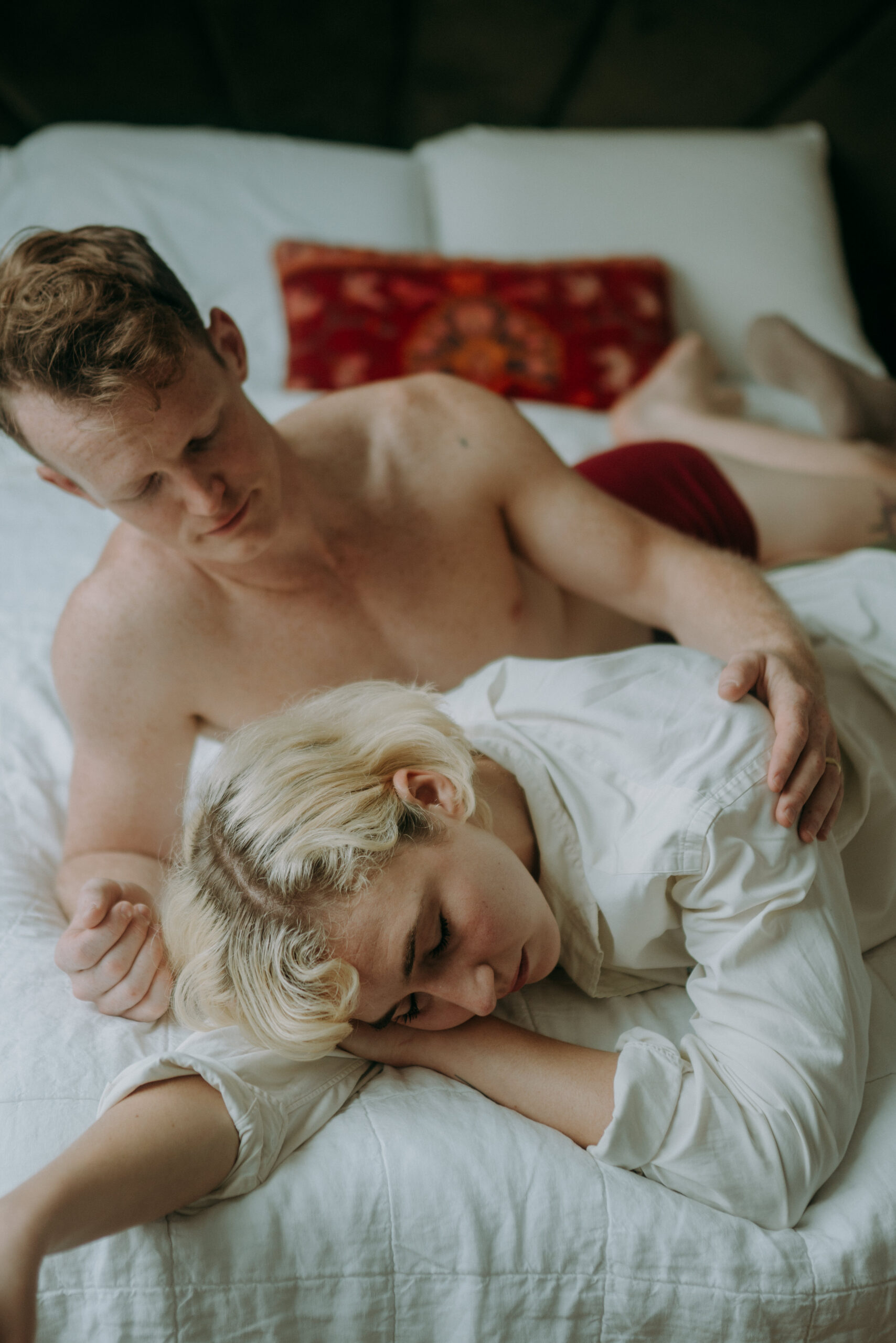 Couple cuddling in bed during intimate couple session NYC morning light natural unposed photography